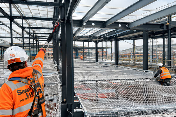 Fall arrest netting installed inside a steel frame building