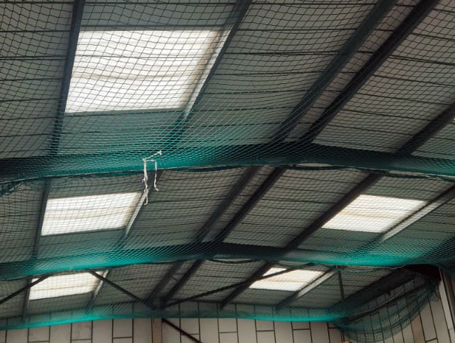 Installing safety netting on industrial building